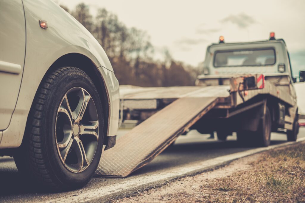 How To Handle Being Stranded On The Road - Loading broken car on a tow truck on a roadside